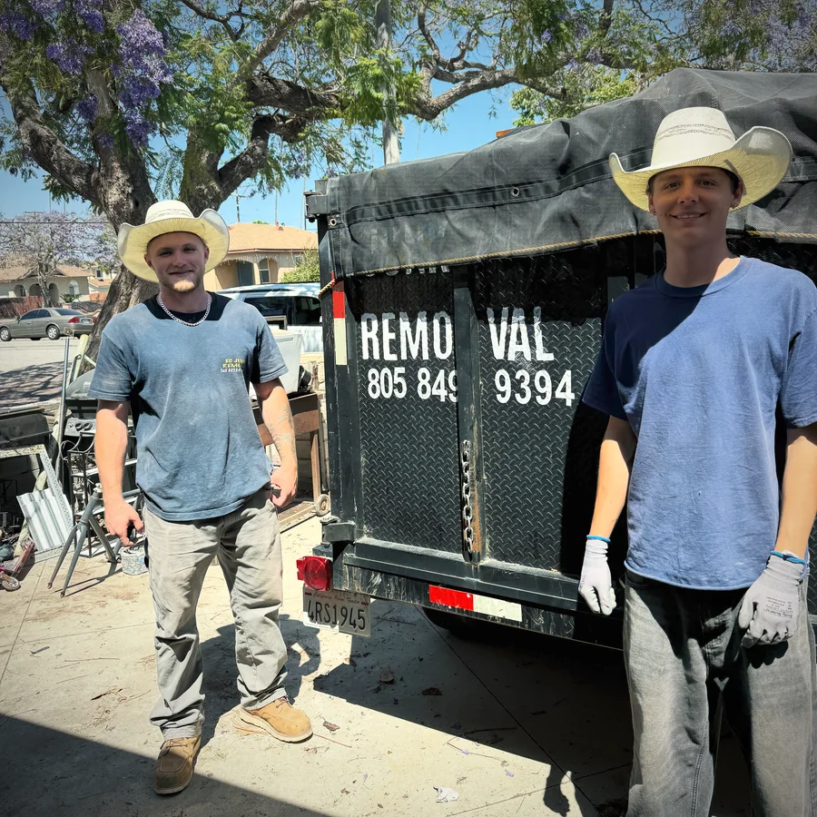 Ezra and Caiden standing beside the EC Junk Removal hauling trailer